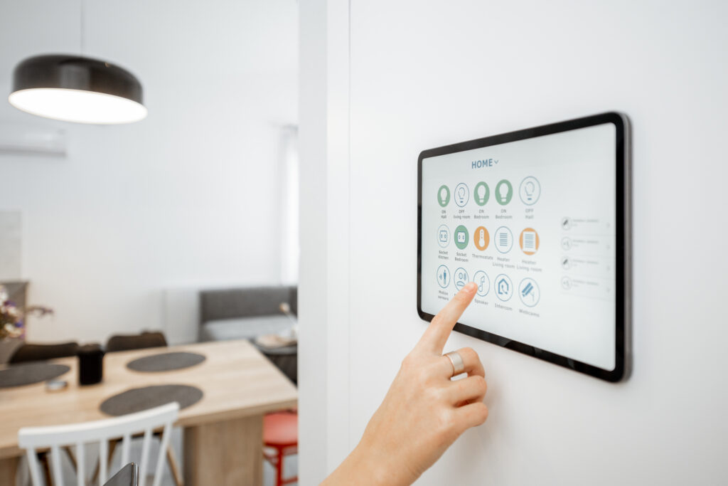 controlling home with a digital touch screen panel installed on the wall. close up on a screen with mobile application for managing smart devices